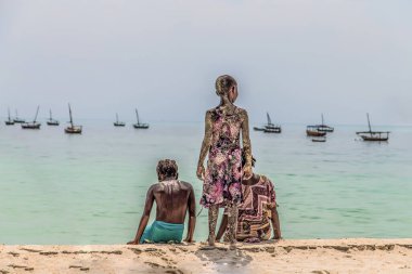 Zanzibar, Tanzanya, Afrika. 30.03. 2018. Mutlu ve kaygısız yerel Tanzanyalı çocuklar güneşli havada okyanus kıyısında oynayıp yüzüyorlar.
