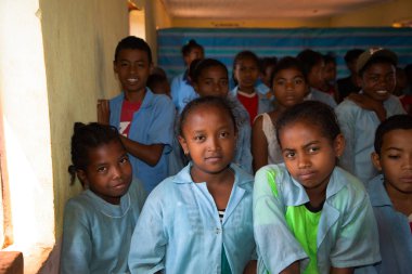 Miandrivazo, Madagaskar 20 Ekim 2023. Sınıfta mutlu okul çocukları var. Okul çocukları gülümser ve öğretmene bakar. Sınıfta bir sürü çocuk var. Çoğu çocuk yalın ayaktır.