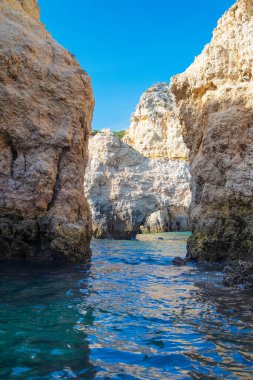 Portekiz 'in Algarve kıyısındaki okyanusta gün batımında şaşırtıcı derecede güzel kayalar. Altın güneş ışınları. Lagos Porugal