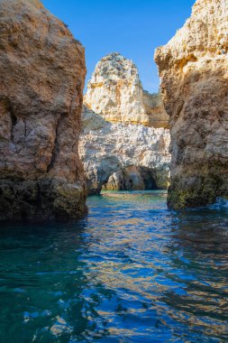 Portekiz 'in Algarve kıyısındaki okyanusta gün batımında şaşırtıcı derecede güzel kayalar. Altın güneş ışınları. Lagos Porugal