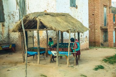 Nişanlı, Madagaskar, 22 Ekim 2023 Madagaskar geleneksel çamur evleri. Çocuklar futbol oynuyor..