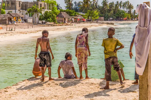 Zanzibar, Tanzanya, Afrika. 30.03. 2018. Mutlu ve kaygısız yerel Tanzanyalı çocuklar güneşli havada okyanus kıyısında oynayıp yüzüyorlar.