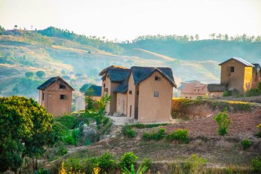 Nişanlısı Madagaskar, 22 Ekim 2023. Madagaskar, Madagaskar 'daki pirinç tarlaları. Düzensiz şekilli basamaklarda küçük açık yeşil filizler var. Malagasy 'nin kil evleri, yamaçlardaki yerel sakinler.