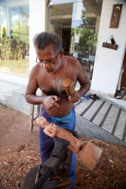 Kolutara, Sri Lanka 09 Şubat 2023. Sri Lanka Geleneksel ağaç ustaları ve zanaatkarları. Ahşaptan el yapımı hediyelik eşya yapmak için küçük bir atölye çalışması. Usta bir Buda heykelciği oyuyor.