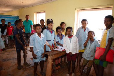 Miandrivazo, Madagaskar 20 Ekim 2023. Sınıfta mutlu okul çocukları var. Okul çocukları gülümser ve öğretmene bakar. Sınıfta bir sürü çocuk var. Çoğu çocuk yalın ayaktır.
