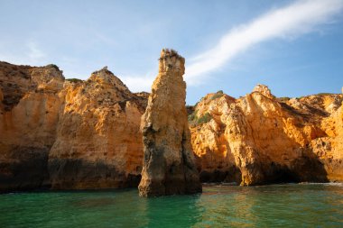 Portekiz 'in Algarve kıyısındaki okyanusta gün batımında şaşırtıcı derecede güzel kayalar. Altın güneş ışınları. Lagos Porugal