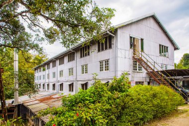 Kandy Yolu, Sri Lanka. 10.02.2023 eski terk edilmiş çay çiftliği Geragama, Sri Lanka Kandy Yolu. Ana bina, çay işleme atölyesi. Dört katlı açık gri bina