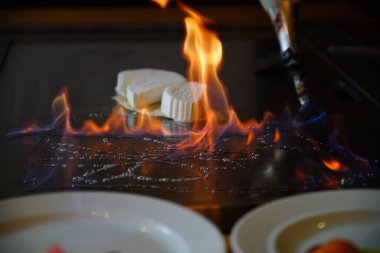 Şefin elleri teppanyaki yerine spatula ile. Sebze pişirmek et ve deniz ürünleri sıcak hibachi ızgara masasında. Geleneksel Japonca. Teppan gösterisi. Dünya mutfağı kavramı