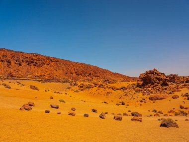 spot in Tenerife with many rocks and beautiful mountain landscape in the background. volcanic landscapes of Tenerife clipart
