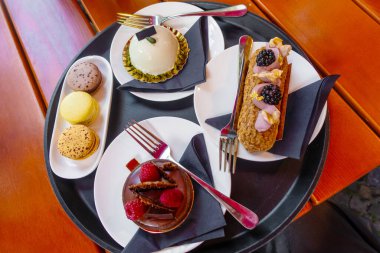 Pasta dükkanından yuvarlak tepside servis edilen çok çeşitli hamur işleri.