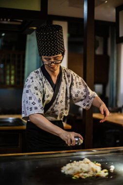 Berlin, Almanya 05. 09 numara. 2019. Teppanyaki şefi bir Japon et lokantasında Teppan 'da yemek pişiriyor. Japon aşçı ateşli bir gösteri sergiliyor.