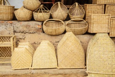Kalamus palmiye dalından mobilya ve sepet yaptıkları küçük bir rattan atölyesi. İnsanlar ve çalışmaları odaklı.