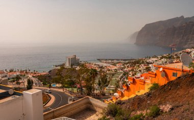 Tenerife, Kanarya Adaları, İspanya 18.04 2022. Dağ yamacının yanındaki kayalık kıyı, deniz ufkunda sis.