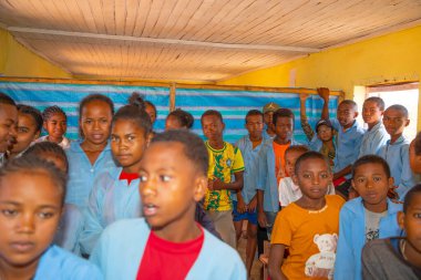 Miandrivazo, Madagaskar 20 Ekim 2023. Sınıfta mutlu okul çocukları var. Okul çocukları gülümser ve öğretmene bakar. Sınıfta bir sürü çocuk var.