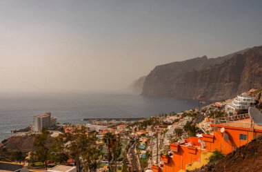 Tenerife, Kanarya Adaları, İspanya 18.04 2022. Dağ yamacının yanındaki kayalık kıyı, deniz ufkunda sis.