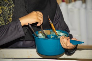 Sanatsal düzenleme Malezya el Batik ekipmanı ve erkek eli aletler. Özel boya pulları ve fırçalar. Batik fabrikasında bir sanatçının işyeri..