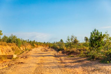 Kırmızı toz ve çamur yolu yağmurdan sonra oluşan büyük delikler ve tümseklerle kötü durumda. Sendrisoa, Madagaskar yakınlarındaki bölgede rotalar son derece kötü.