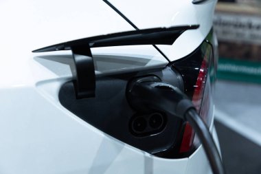 Kapalı EV şarj kolu fişe takıldı veya elektrikli arabaya bağlandı, EV araba aküsünü temiz çevre için sıfır CO2 emisyonu ile alternatif ve sürdürülebilir enerjiyle şarj etti. Çevre dostu