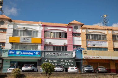 Sandakan, Sabah, Malezya. Malezya 'nın Sandakan şehrinin caddesi boyunca giden bir arabanın penceresinden 17.08.2024 numaralı manzara. Geleneksel evler ve dükkanlar