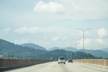 Yollar arasındaki geleneksel Asyalılar. Güneşli bir günde gökyüzü bulutlu yeşil dağ ve yollar.