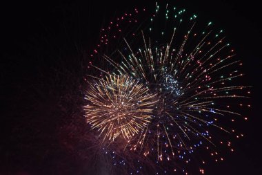 Karanlık gökyüzünde havai fişek festivali. Siyah bir arkaplanda sayısız küçük renkli parlak ışık