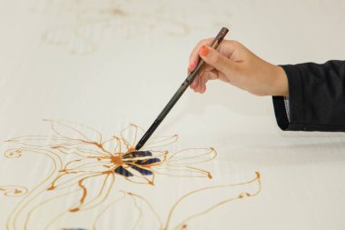 Kuala Lumpur, Malezya. 04.08.2024. Malezya Batik Kumaşındaki Fırça Boyalı El adlı kadın..