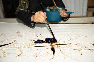 Kuala Lumpur, Malezya. 04.08.2024. Malezya Batik Kumaşındaki Fırça Boyalı El adlı kadın..