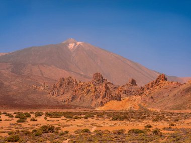 spot in Tenerife with many rocks and beautiful mountain landscape in the background. volcanic landscapes of Tenerife clipart