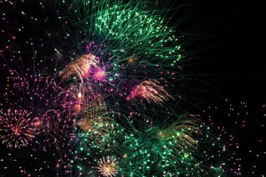 Karanlık gökyüzünde havai fişek festivali. Siyah bir arkaplanda sayısız küçük renkli parlak ışık