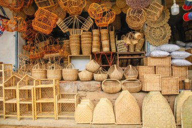 Kalamus palmiye dalından mobilya ve sepet yaptıkları küçük bir rattan atölyesi. İnsanlar ve çalışmaları odaklı.