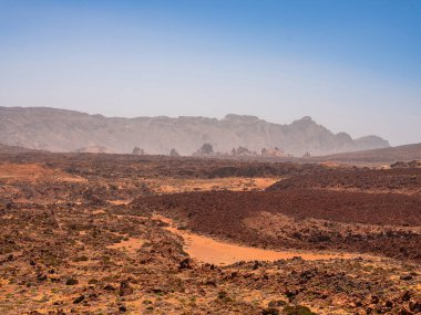 spot in Tenerife with many rocks and beautiful mountain landscape in the background. volcanic landscapes of Tenerife clipart