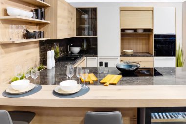 Minimalist, ahşap mutfak iç mimarisi ergonomik biuld mutfak ve mutfak adası. Modern mutfak eşyaları ve şarap kadehleri.