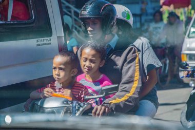 Antananarivo, Madagaskar 07 Ekim 2023 Tana, başkent Madagaskar, Fransızca adı Tananarive, Tana. Şehrin günlük hayatı. Ailesi olan küçük çocuklar kasksız motosiklet kullanıyorlar.