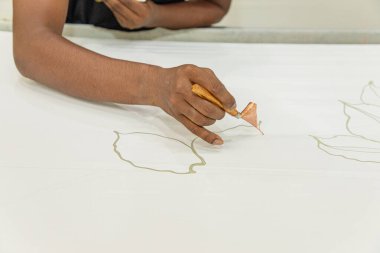 Malezya Batik Kumaşı 'nda Batik' i boyayan özel balmumu alet fırçasıyla yakın plan adamı El.