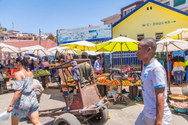 Antananarivo, Madagaskar. 06.10. 2023 başkent Madagaskar. Güneşli bir günde sokakta bir sürü insan olur. İnsanlar yemek satar, ev eşyaları kendi işlerine bakar. Antananarivo 'nun mimarisi. Günlük hayat.