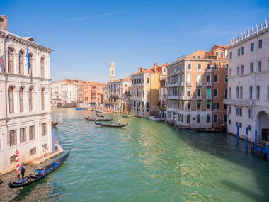 Venedik, İtalya. 28.10 dolar. 2022 yılı. İtalya, Venedik 'te Rialto Köprüsü ve gondolcularıyla Büyük Kanal manzarası. Venedik 'teki Grand Canal' da Rialto Köprüsü ve gondollu manzara