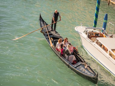 Venedik, İtalya. 28.10 dolar. 2022 yılı. İtalya, Venedik 'te Rialto Köprüsü ve gondolcularıyla Büyük Kanal manzarası. Venedik 'teki Grand Canal' da Rialto Köprüsü ve gondollu manzara