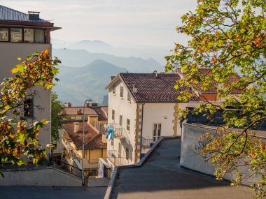San Marino Cumhuriyeti. Dağdaki 31.10.2022 antik kale. Dar sokaklar turist, restoran ve hediyelik eşya dükkanlarıyla dolu. Aşağıda gün batımında güzel bir dağ manzarası var.
