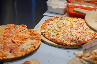 İki dilim taze hazırlanmış ve satışa hazır pizza. Dilimlenmiş sıcak pizza dilimi erimiş peynir.