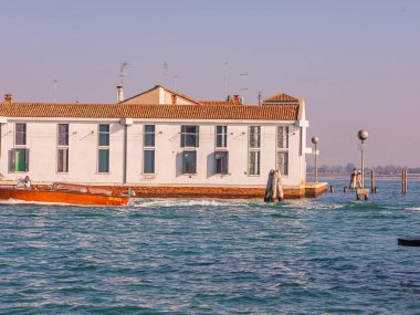 Murano, Venedik, İtalya Murano 29.10.2022 Kuzey lagün ve cam fabrikalarındaki ada. Gün batımında Venedik 'te Murano kanalları. Renkli eski evler ve köprüler kanal kıyılarını birbirine bağlıyor
