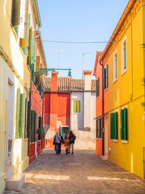 Burano, Venedik, İtalya 29.10.2022. Burano adası, Venedik bölgesi. Kanalların farklı taraflarındaki parlak renkli evler ve suda renkli yansımalar.