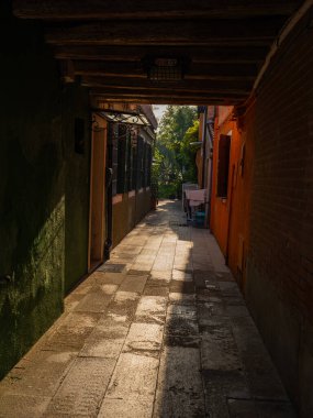 Burano, Venedik, İtalya 29.10.2022. Burano adası, Venedik bölgesi. Kanalların farklı taraflarındaki parlak renkli evler ve suda renkli yansımalar.