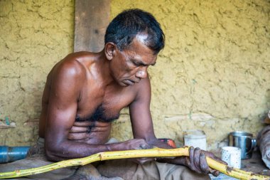 Sri Lanka 07.02.2023 Srilankalı bir işçi geleneksel yollarla tarçın hazırlıyor. Tişörtsüz bir işçi, Seylan 'da bir bıçakla ağaç kabuğunu soyar.