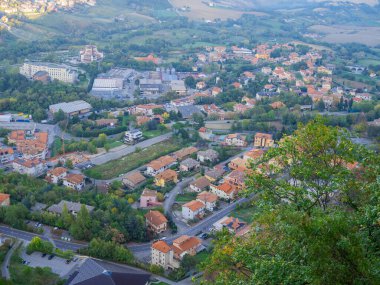 San Marino Cumhuriyeti. Dağdaki 31.10.2022 antik kale. Dar sokaklar turist, restoran ve hediyelik eşya dükkanlarıyla dolu. Aşağıda gün batımında güzel bir dağ manzarası var.