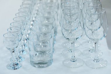 Alkol için saydam bardaklar beyaz masanın üzerinde duruyor..