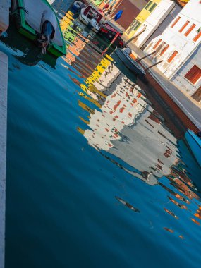Burano, Venedik, İtalya 29.10.2022. Burano adası, Venedik bölgesi. Kanalların farklı taraflarındaki parlak renkli evler ve suda renkli yansımalar.