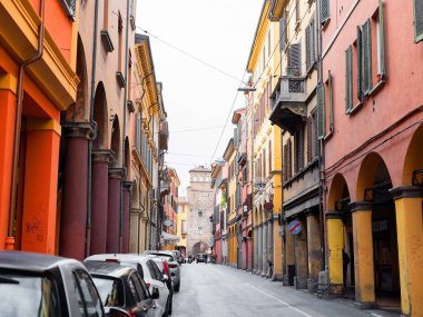 Bolonya, İtalya. 01.11. 2022 İtalya 'da Bolonya şehri. Evlerin ön cepheleri şehir merkezine giden parlak terracotta gölgeleridir. Eski moda evler tam olarak dar bir sokakta duruyor.