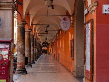Bolonya, İtalya. 01.11. 2022 İtalya 'da Bolonya şehri. Evlerin ön cepheleri şehir merkezine giden parlak terracotta gölgeleridir. Eski moda evler tam olarak dar bir sokakta duruyor.