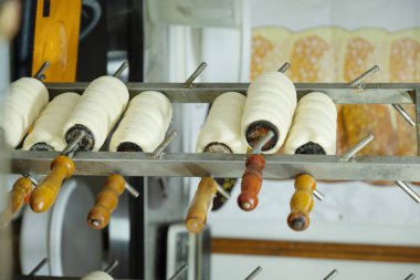 Pek çok yeni Çek Trdelnik 'i özel bir ızgaranın üzerinde pişmeye hazır olarak yatıyor. Geleneksel Çek sokak yemekleri