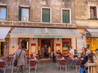 Venedik, İtalya. 28.10.2022 Venedik 'in en popüler turizm merkezi değil. Şehrin varoşlarında. Kanallar, evler ve köprüler. Dışarıda birkaç masası olan küçük bir kafe.